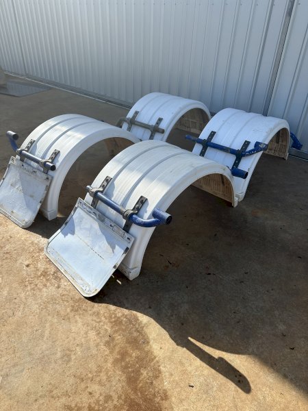 Four plastic truck mudguards with mounting hardware.