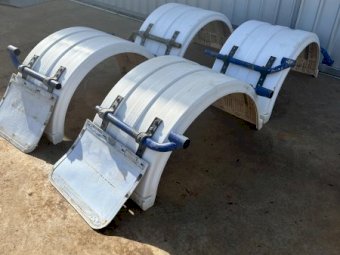 Four plastic truck mudguards with mounting hardware.