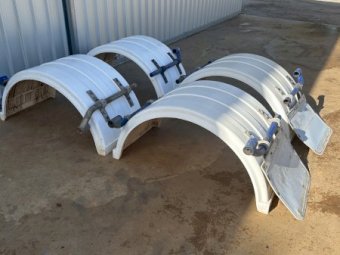 Four plastic truck mudguards with mounting hardware.